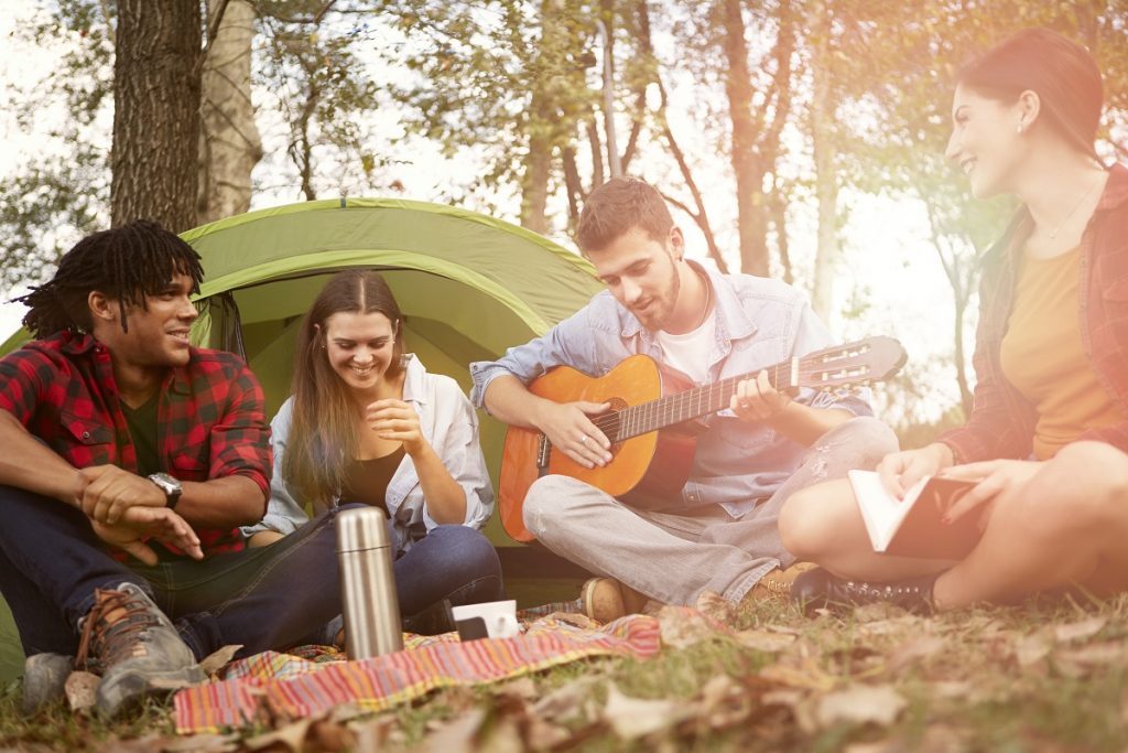 people on a camping playing the guitar