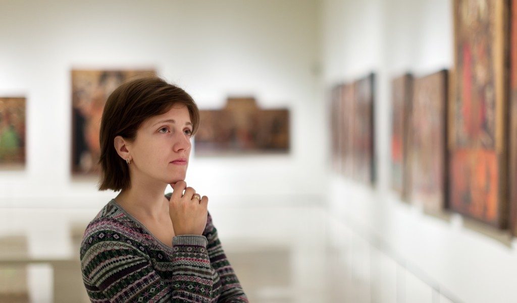 visitor looking pictures in art gallery