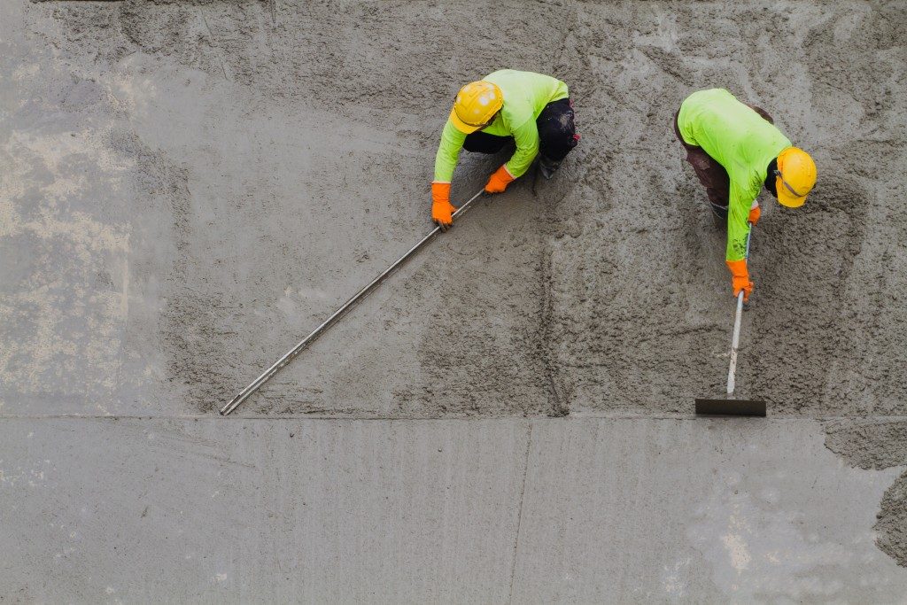workers flatenning the concrete floor