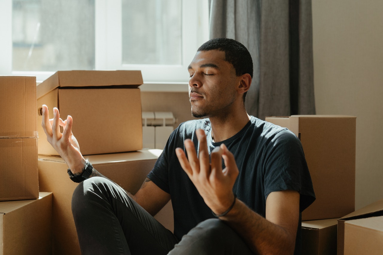 person meditating among some boxes