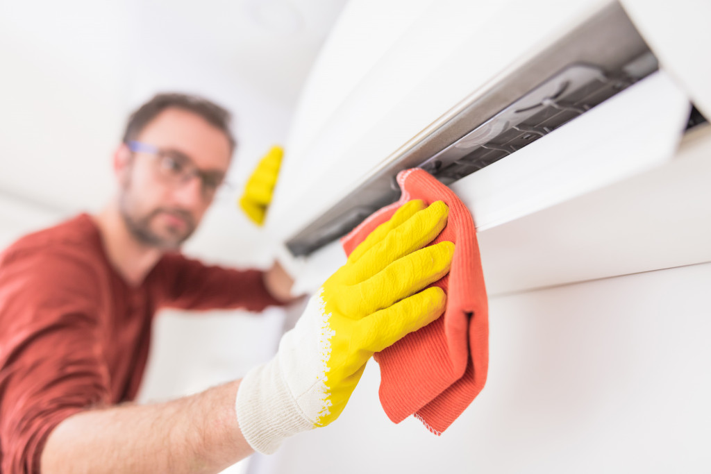 A technician cleaning the air filters of an air conditioning unit.