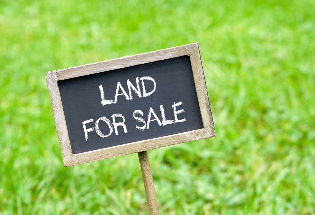 A land for sale sign on a grassy lawn