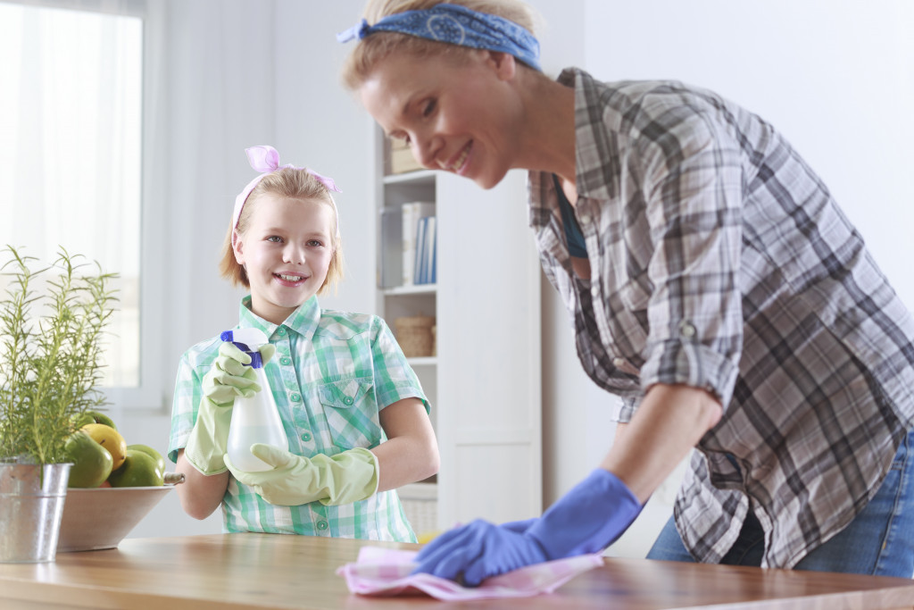 woman cleaning a table with daughter