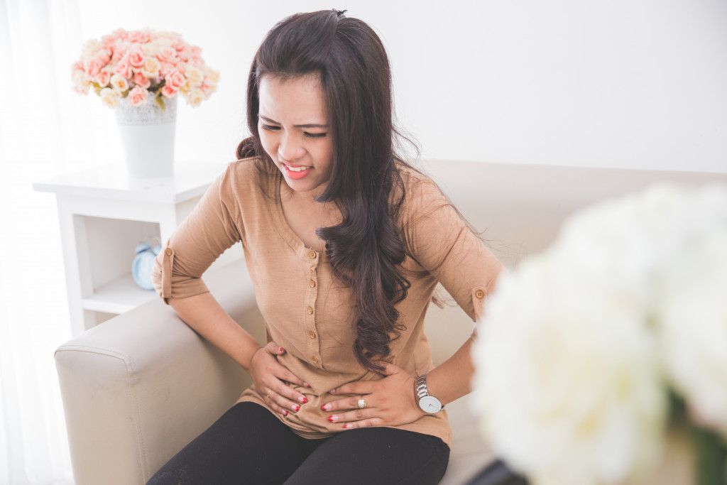 Woman grasping her stomach while in pain