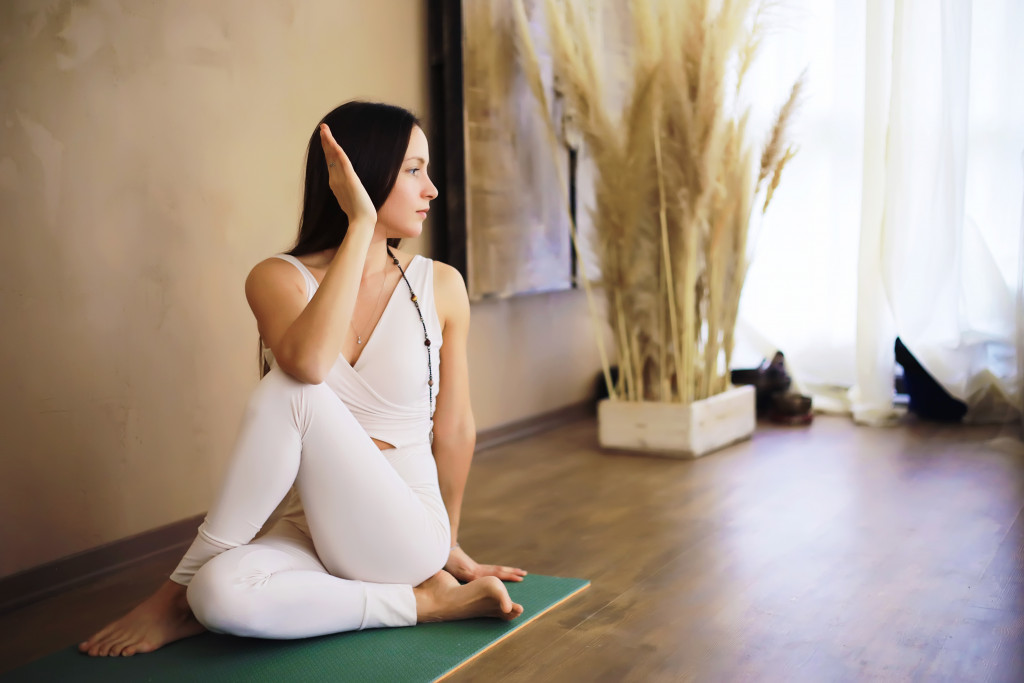 a woman holding her head while in meditation at home