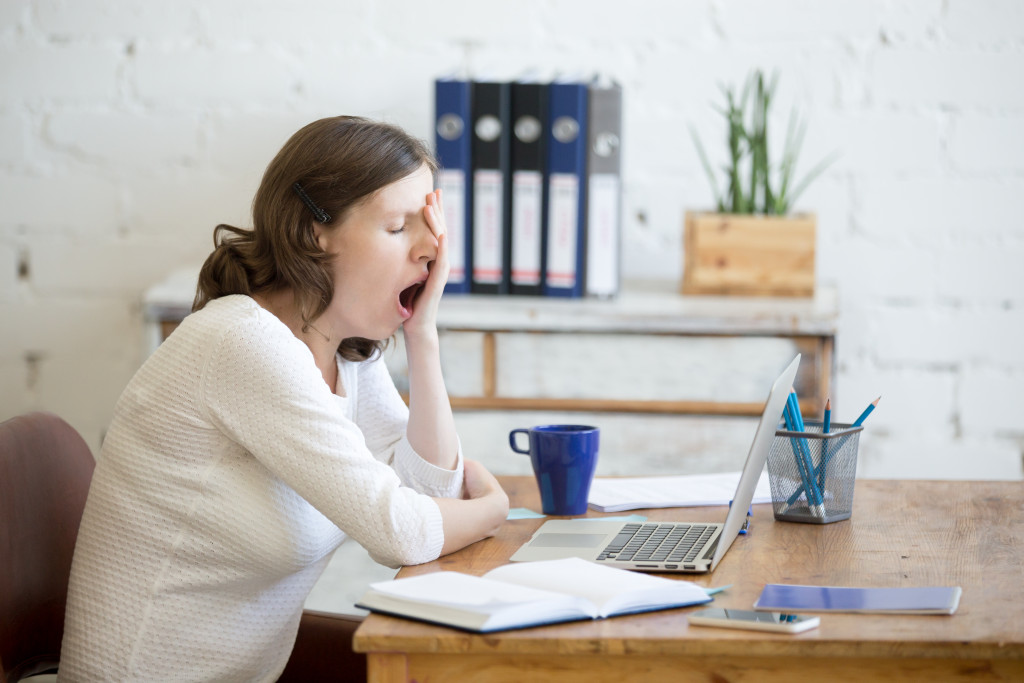 A woman feeling sleepy while at work