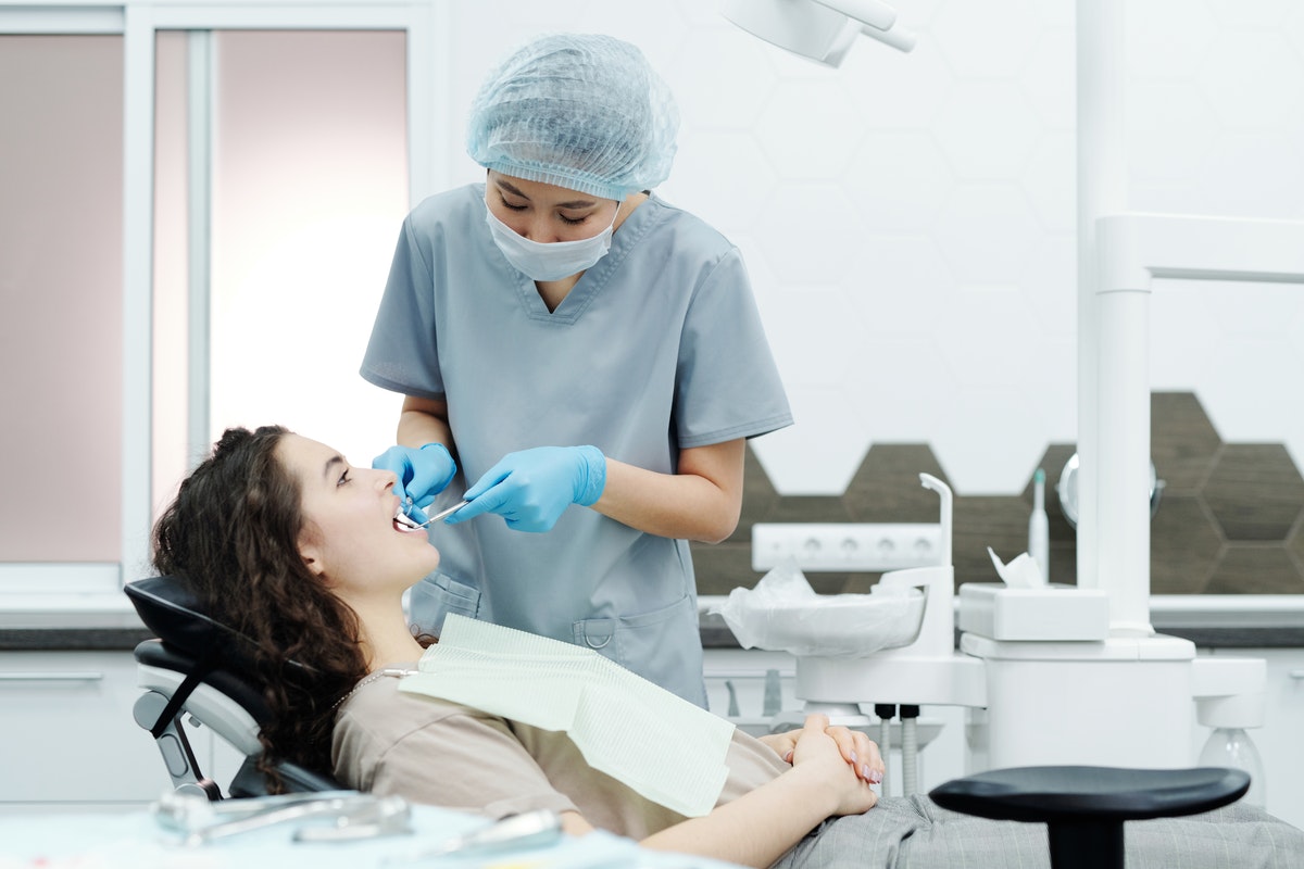 dentist fixing a female patient's teeth