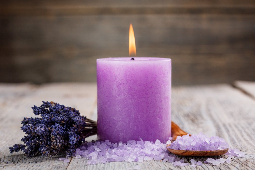 Purple scented candle with salt and dried flowers.