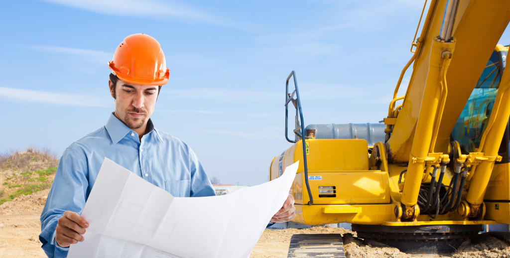 engineer with a backhoe in the background