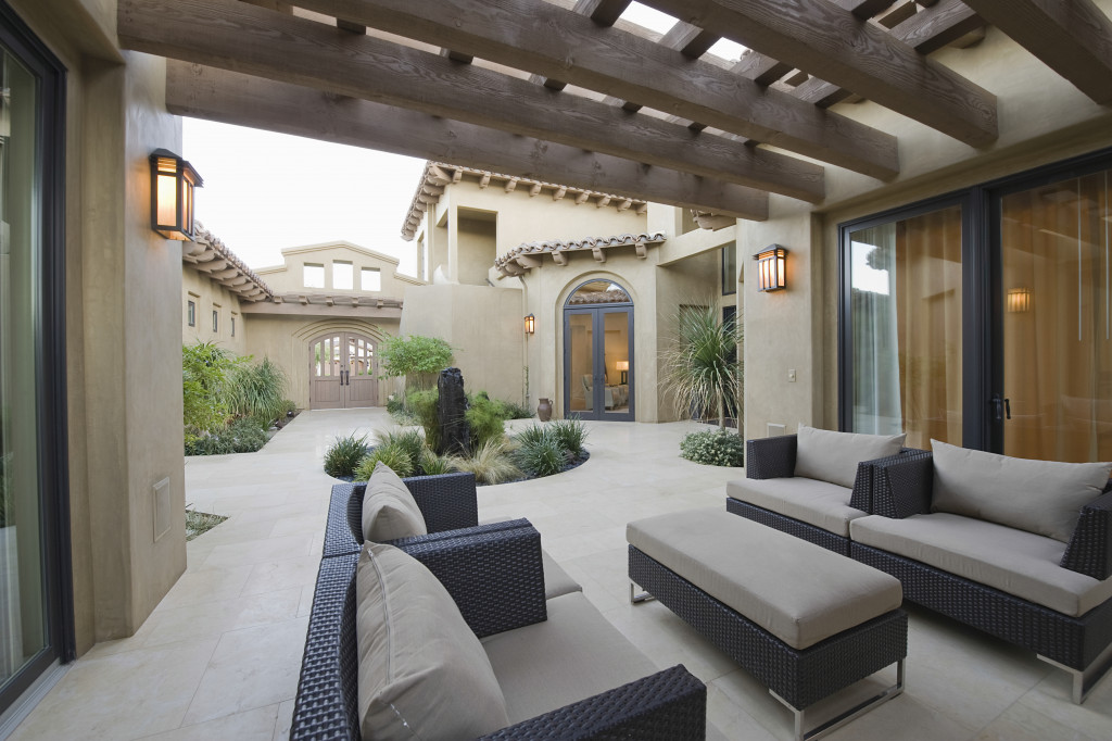 Outdoor living area with couches, a table, and patio cover in a modern home.