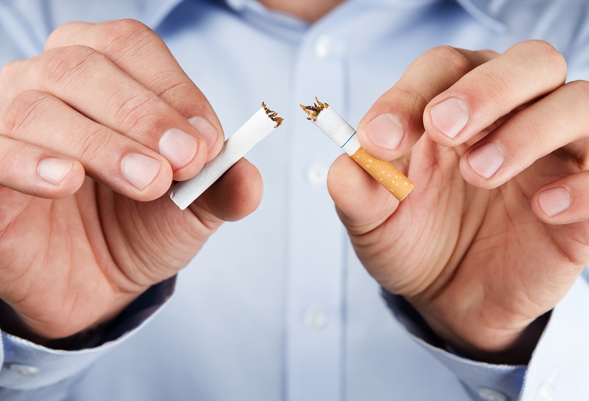 man breaking cigarette in half