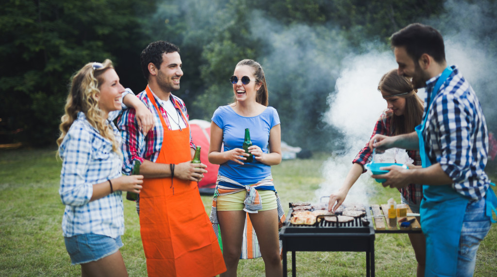 friends having fun grilling BBQ at the backyard