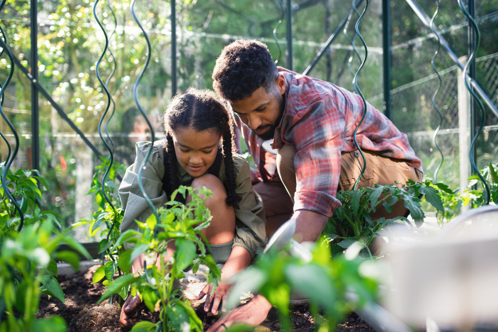 a dad with his daughter gardening