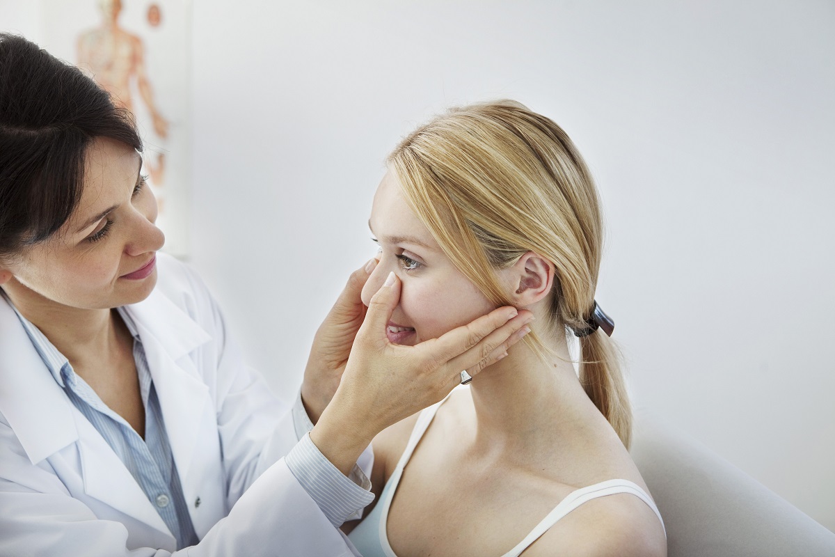 a female doctor treating the face of a woman using dermatology